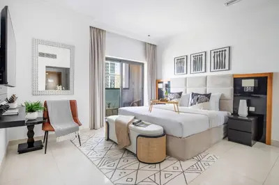 a bedroom with a large bed and a desk at Frank Porter - Capital Bay Tower B in Dubai