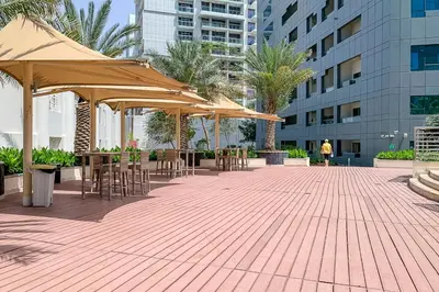 a patio with tables and umbrellas in a building at Frank Porter - Capital Bay Tower B in Dubai
