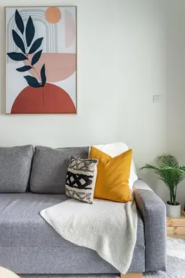 a living room with a gray couch with yellow pillows at GuestReady - Jumeirah Skyline Apartment in Dubai