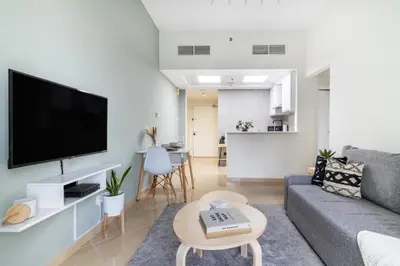 a living room with a gray couch and a flat screen tv at GuestReady - Jumeirah Skyline Apartment in Dubai