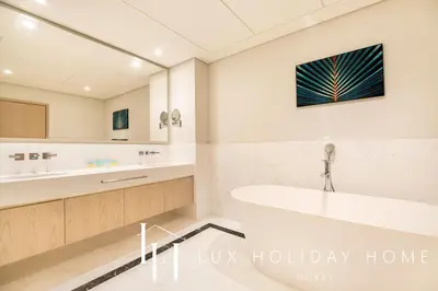 a bathroom with a tub and a large mirror at LUX Iconic Views at The Palm Tower Suite 2 in Dubai