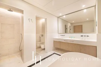 a bathroom with a sink and a toilet and a mirror at LUX Iconic Views at The Palm Tower Suite 2 in Dubai
