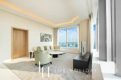 a living room with a couch and a tv at LUX Iconic Views at The Palm Tower Suite 3 in Dubai