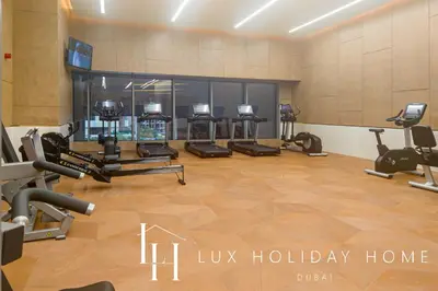 a gym with several treadmills and exercise bikes at LUX Iconic Views at The Palm Tower Suite 3 in Dubai