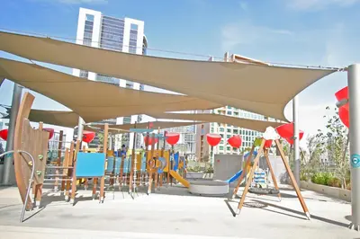 a childrens playground with awning and swings at Luxury MAG 318 Studio Near Dubai Mall in Dubai