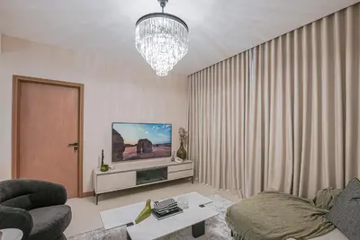 a living room with a couch and a chandelier at Modern 2BR High Floor Haven in Vida Dubai Marina in Dubai