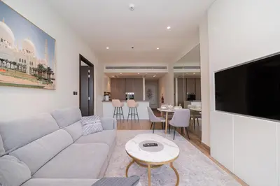a living room with a couch and a tv and a table at Luton Vacation Homes - Luxury & Sea View 1BR - Jumeirah Living Marina Gate Tower 3 - 40AB12 in Dubai