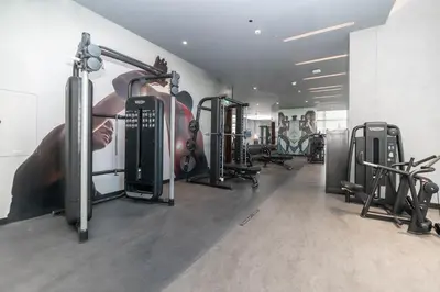 a gym with several treadmills and exercise bikes at Luton Vacation Homes - Luxury & Sea View 1BR - Jumeirah Living Marina Gate Tower 3 - 40AB12 in Dubai