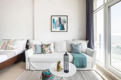 a living room with a white couch and a table at Frank Porter - Siraj Tower in Dubai