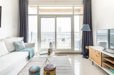 a living room with a white couch and a large window at Frank Porter - Siraj Tower in Dubai