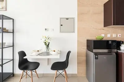 a kitchen with a table and chairs and a refrigerator at Frank Porter - Siraj Tower in Dubai