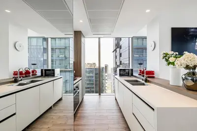 a kitchen with white counters and a large window at 2BR Marina Gate 3 High Floor Marina View in Dubai