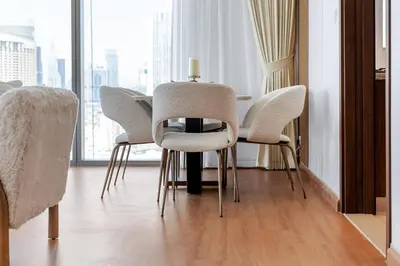 a dining room table with white chairs and a window at boulevard point view in Dubai