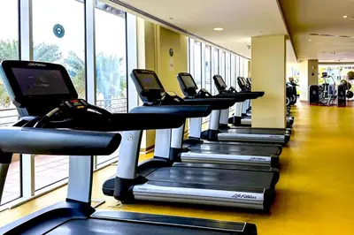 a row of cardio treadmills in a gym at Tiara Residence - Palm Jumeirah Dubai in Dubai