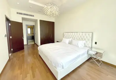 a bedroom with a large white bed and a chandelier at Tiara Residence - Palm Jumeirah Dubai in Dubai