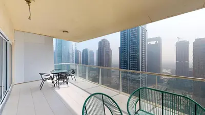 a balcony with a table and chairs on top of a building at LV38 - Elegant 2BHK in Lake View Tower in Dubai