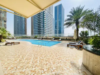 a swimming pool in a building with tall buildings at LV38 - Elegant 2BHK in Lake View Tower in Dubai
