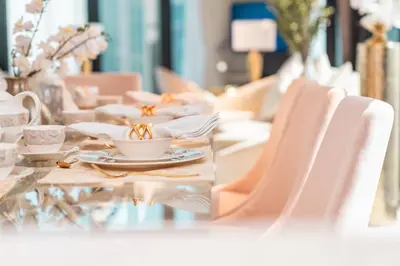 a table with white chairs and a cup of coffee at Elite Royal Apartment - Panoramic Burj Khalifa, Fountain & Dubai skyline view - Marquise in Dubai