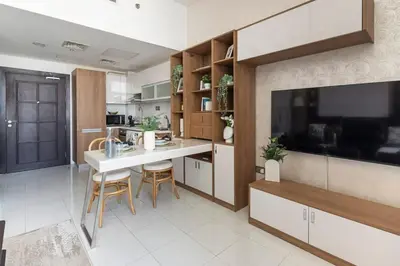 a kitchen with a table and chairs and a television at Frank Porter - Starz by Danube in Dubai