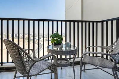 a balcony with two chairs and a table with a plant at Frank Porter - Starz by Danube in Dubai