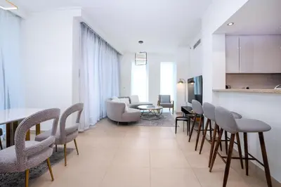 a living room with chairs and a table at Vacay Lettings - High floor Burj Khalifa & Fountain view 3 bed in Dubai