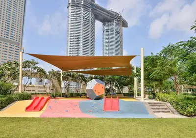 a playground in a park with tall buildings at Vacay Lettings - High floor Burj Khalifa & Fountain view 3 bed in Dubai
