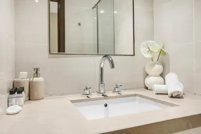 a bathroom with a sink and a mirror at Luxury 3BR with Burj Khalifa Views, Pool, Gym, and Free Parking in Dubai