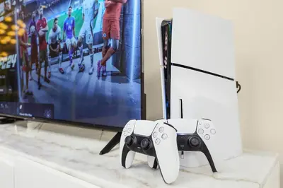 a video game controller sitting next to a tv at Luxury 3BR with Burj Khalifa Views, Pool, Gym, and Free Parking in Dubai