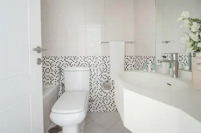 a white bathroom with a toilet and a sink at Frank Porter - Marina Wharf 2 in Dubai