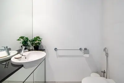 a white bathroom with a sink and a toilet at Silkhaus contemporary 1BDR with Downtown view in DIFC in Dubai