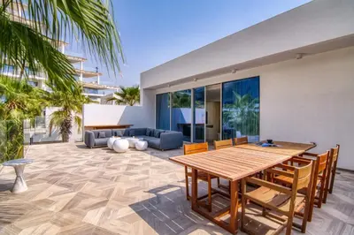 a patio with a wooden table and chairs at FIVE Palm Beachfront Villa -Private Pool & Jacuzzi, Panoramic Views, by Exclusive Holiday Homes in Dubai