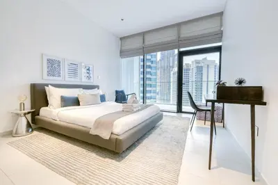 a bedroom with a bed and a desk and a window at Maison Privee - Luxury Apt with Burj Khalifa Vw & Dubai Canal Access in Dubai