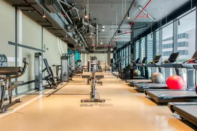 a gym with rows of tread machines at Maison Privee - Luxury Apt with Burj Khalifa Vw & Dubai Canal Access in Dubai