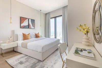 a white bedroom with a large bed and a desk at Frank Porter - The Address JBR in Dubai