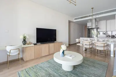 a living room with a tv and a table with chairs at Frank Porter - The Address JBR in Dubai