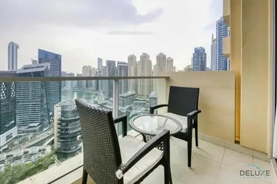 a balcony with two chairs and a glass table at Steps Away From Marina Mall with Iconic Marina Canal Views, The Address Residences, Dubai Marina by Deluxe Holiday Homes in Dubai