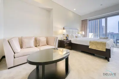 a hotel room with a bed and a couch and a table at Steps Away From Marina Mall with Iconic Marina Canal Views, The Address Residences, Dubai Marina by Deluxe Holiday Homes in Dubai