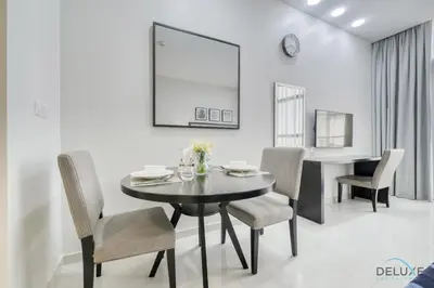 a dining room with a black table and chairs at Superb Studio at Damac Celestia A Dubai South By Deluxe Holiday Homes in Dubai
