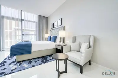 a bedroom with a bed and a chair at Superb Studio at Damac Celestia A Dubai South By Deluxe Holiday Homes in Dubai