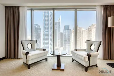 a living room with two chairs and a table and a large window at Pristine 3BR at The Address Residences Dubai Marina by Deluxe Holiday Homes in Dubai