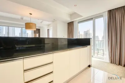 a kitchen with white cabinets and a large window at Pristine 3BR at The Address Residences Dubai Marina by Deluxe Holiday Homes in Dubai