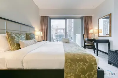 a hotel room with a large bed and a desk at Regal Studio at The Address Residences Dubai Marina by Deluxe Holiday Homes in Dubai