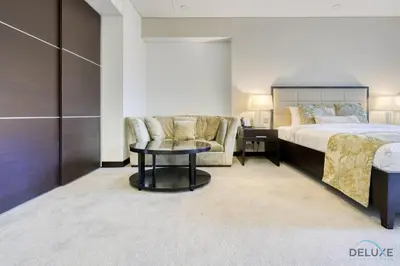 a bedroom with a bed and a couch and a table at Regal Studio at The Address Residences Dubai Marina by Deluxe Holiday Homes in Dubai