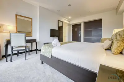 a bedroom with a large bed and a desk at Regal Studio at The Address Residences Dubai Marina by Deluxe Holiday Homes in Dubai