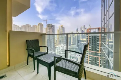 a balcony with two chairs and a view of a city at Regal Studio at The Address Residences Dubai Marina by Deluxe Holiday Homes in Dubai