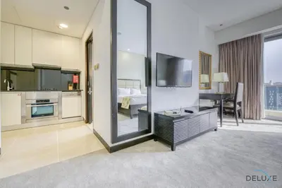 a living room with a television and a bedroom at Upscale Studio at The Address Residences Dubai Marina by Deluxe Holiday Homes in Dubai