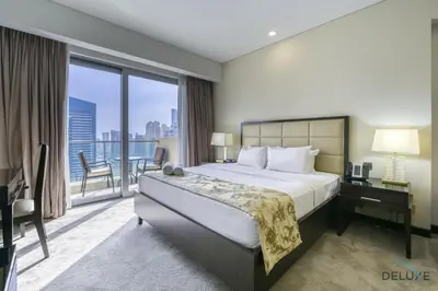 a bedroom with a large bed and a balcony at Upscale Studio at The Address Residences Dubai Marina by Deluxe Holiday Homes in Dubai