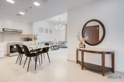 a kitchen and dining room with a table and a mirror at Fancy 2BR at Hayat Boulevard 2A Town Square By Deluxe Holiday Home in Dubai