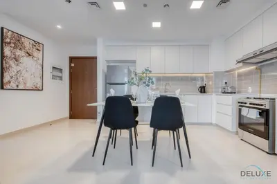 a kitchen with a table and two chairs at Fancy 2BR at Hayat Boulevard 2A Town Square By Deluxe Holiday Home in Dubai