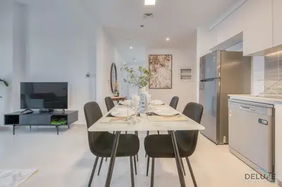 a kitchen and dining room with a table and chairs at Fancy 2BR at Hayat Boulevard 2A Town Square By Deluxe Holiday Home in Dubai